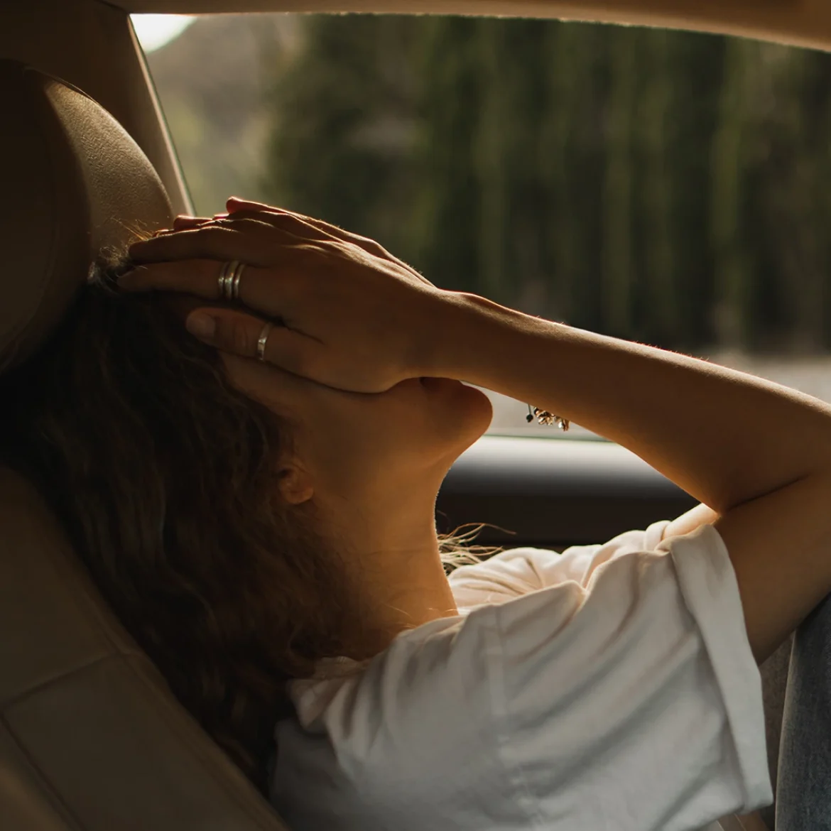 Vrouw zit in auto en houdt haar handen voor haar gezicht, arrestatie, eerste date