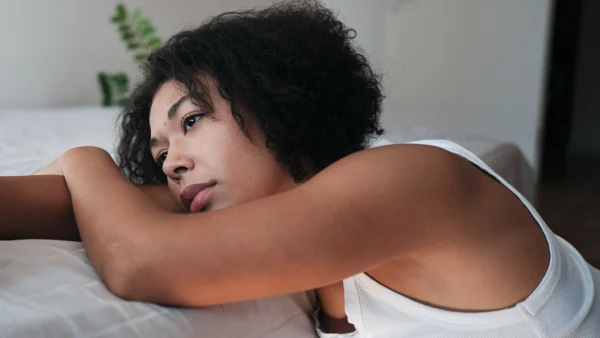 Stiefmoeder Babelle ligt op bed en leunt op haar arm, ex vriend