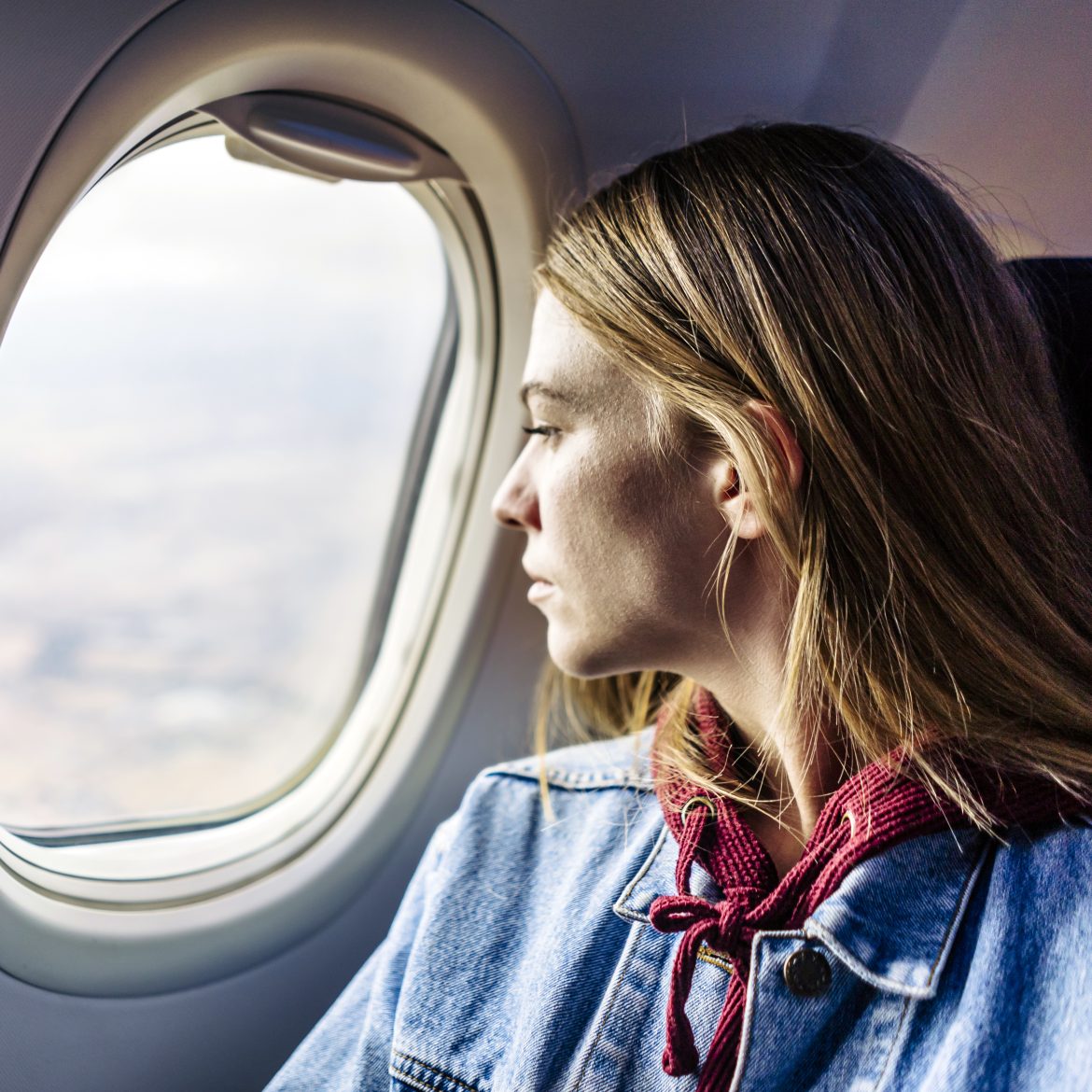 Vrouw kijkt uit het vliegtuigraam
