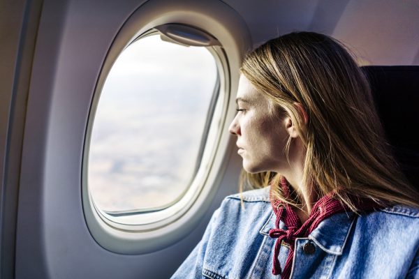 Vrouw kijkt uit het vliegtuigraam