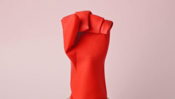 Rode rubberen handschoenen die een vuist maakt