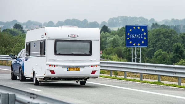 caravan op de snelweg bij grensbord met Frankrijk