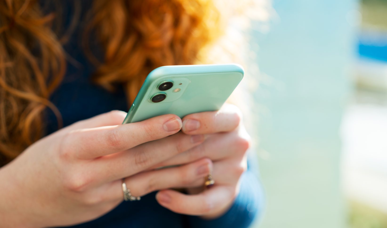 vrouw met rood haar met een groene telefoon in haar handen