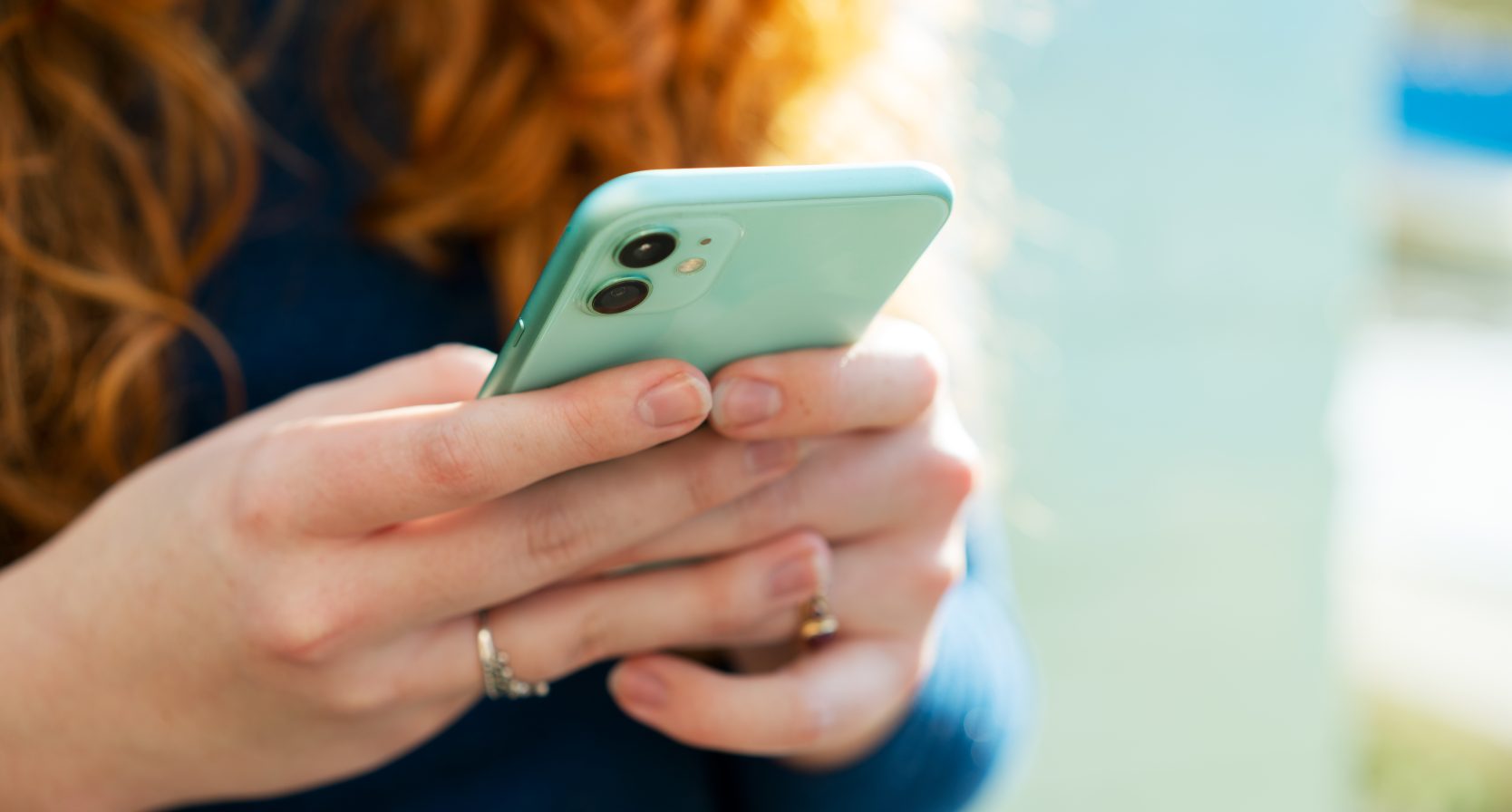 vrouw met rood haar met een groene telefoon in haar handen