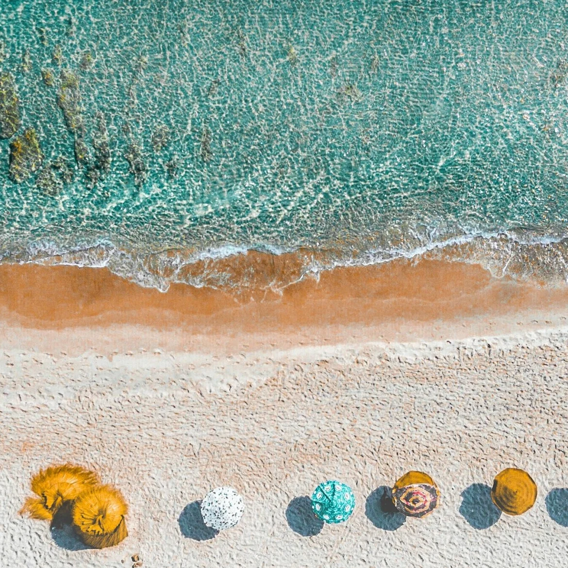 Gele parasols op het strand, dicht bij de zee.