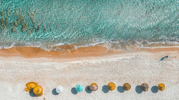 Gele parasols op het strand, dicht bij de zee.