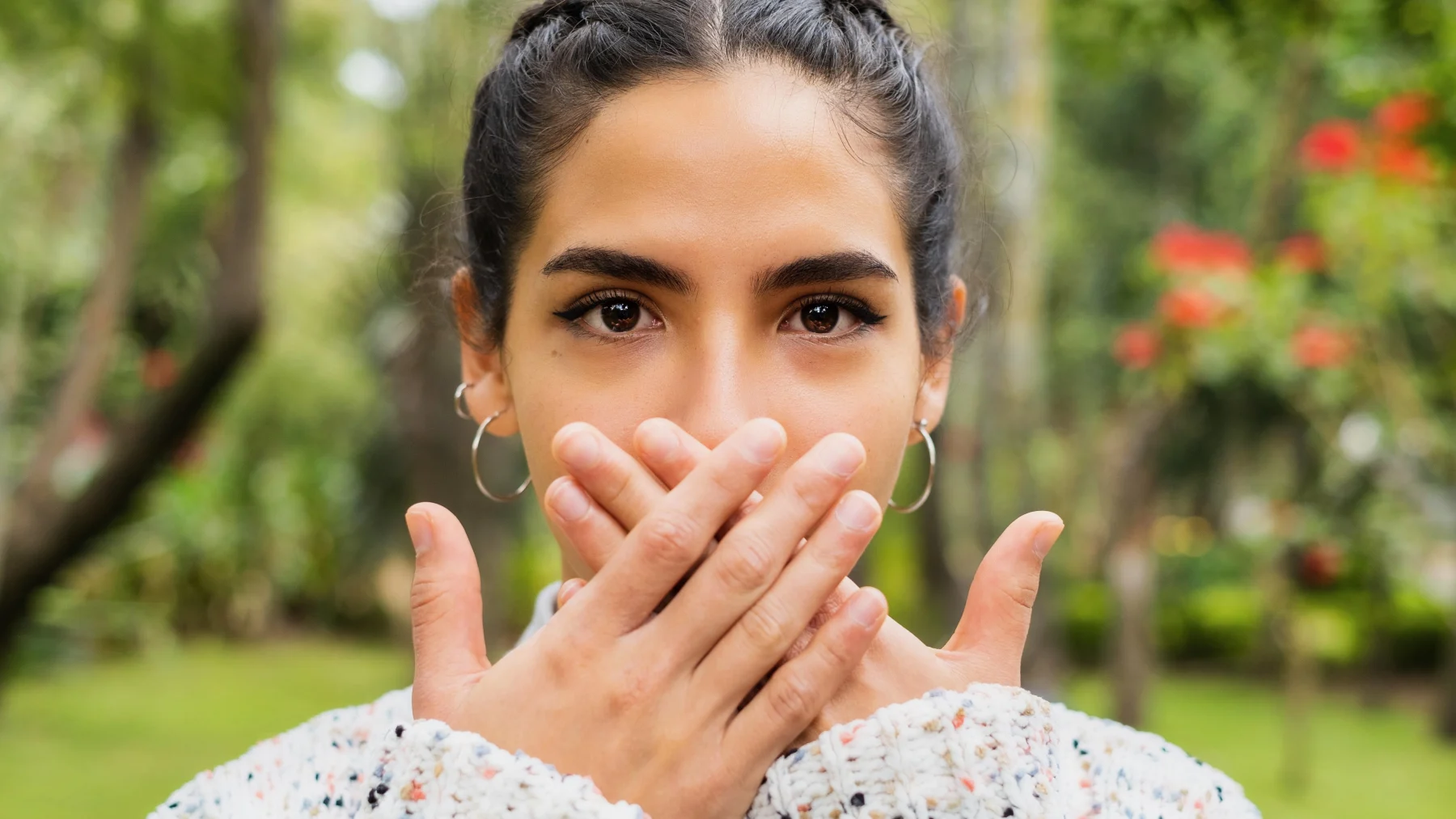 Een vrouw houdt haar handen voor haar mond. Deel je geheim met LINDA.