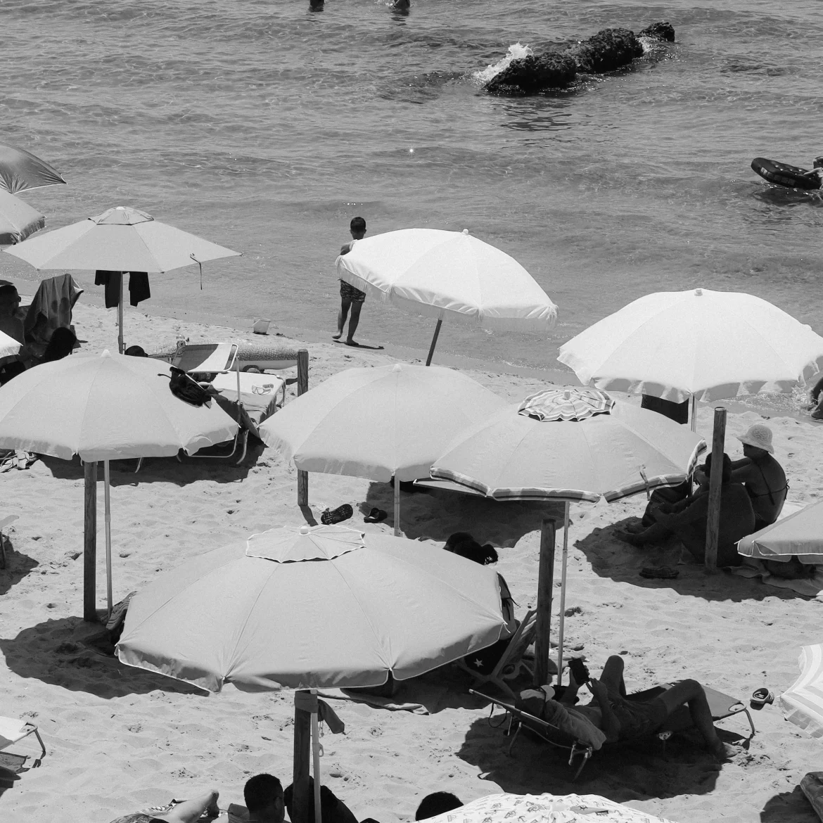 parasols en mensen op het strand.