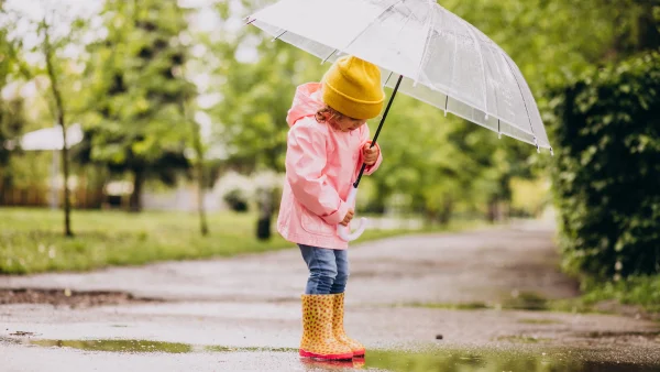 kind met paraplu in de regen | tropisch weer