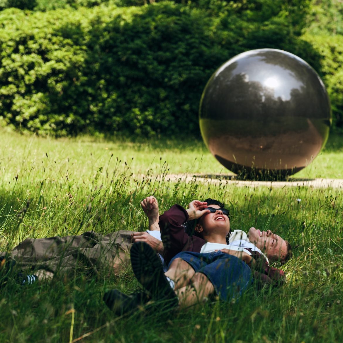 man en vrouw in gras bij kunstwerk