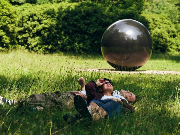 man en vrouw in gras bij kunstwerk