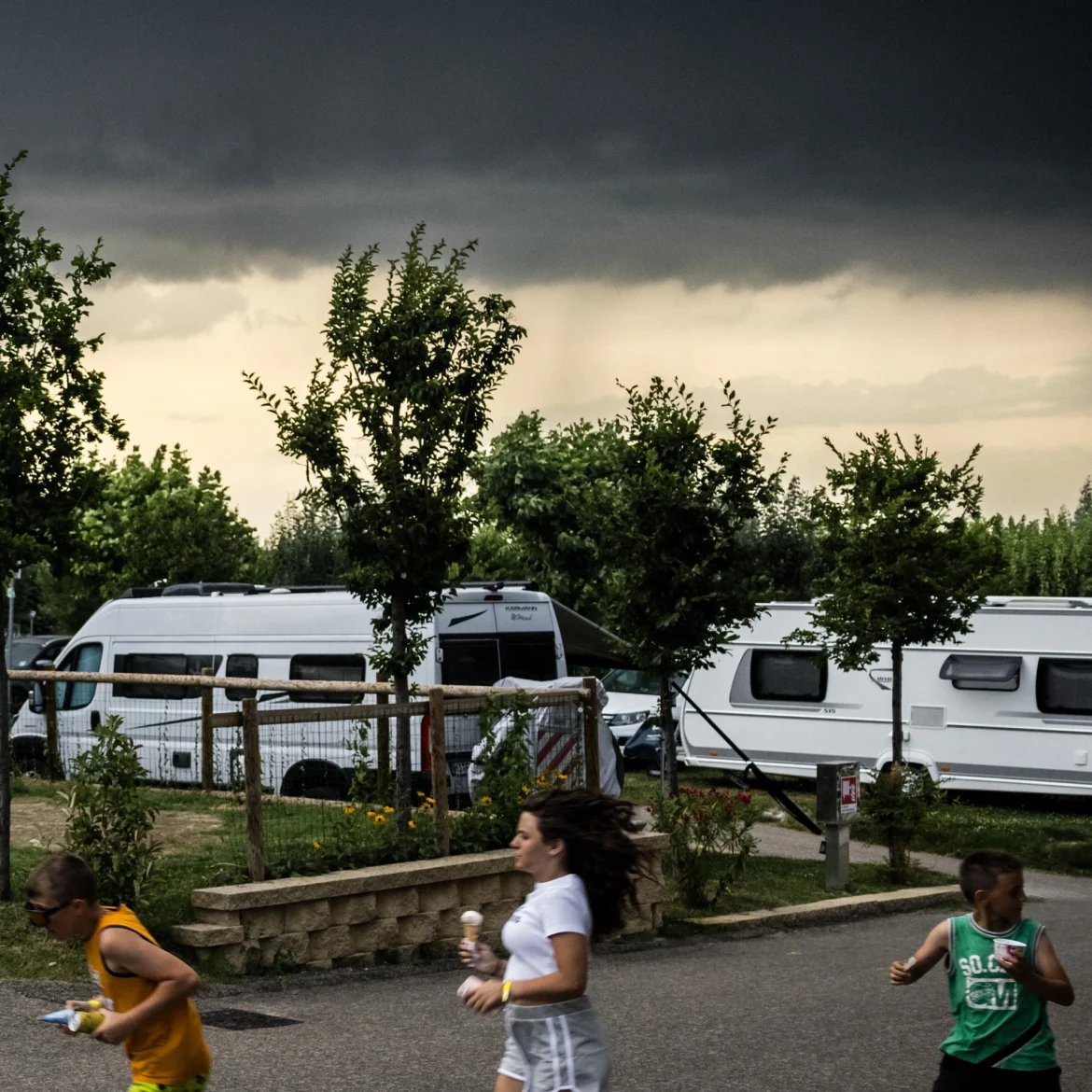 Noodweer verwacht Alpen Italië Zwitserland Oostenrijk kinderen rennen donkere wolken camping