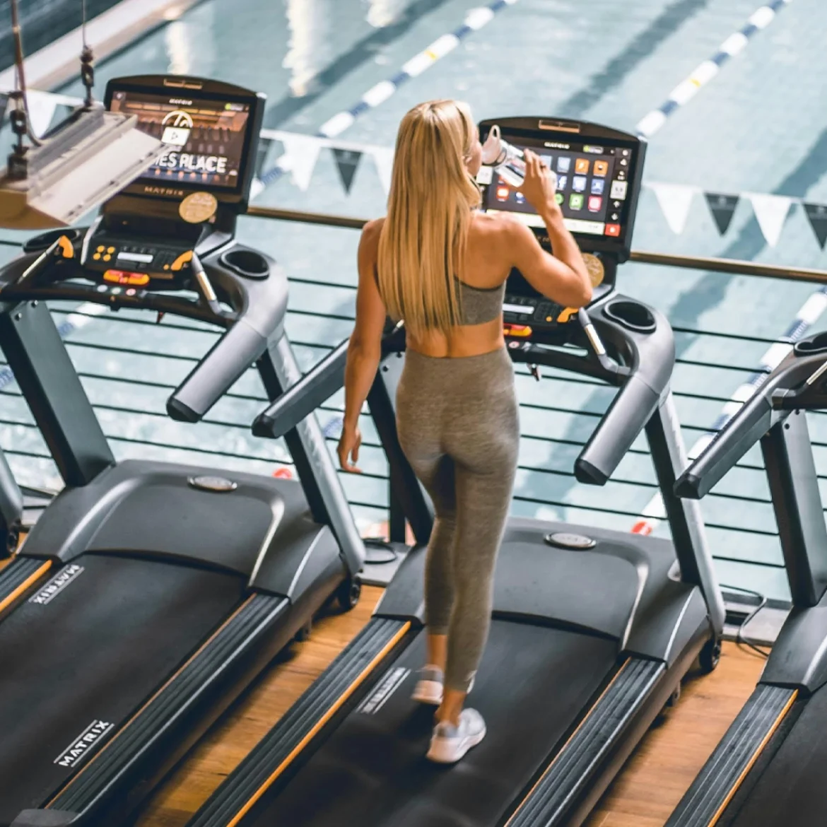 Vrouw rent op hardloopband in sportschool
