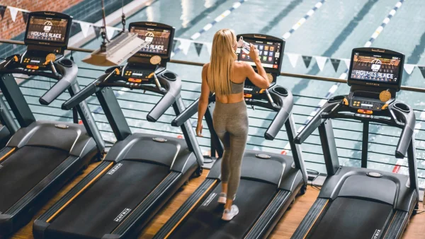 Vrouw rent op hardloopband in sportschool
