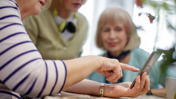 Oma laat foto's van kleinkinderen zien aan vriendinnen