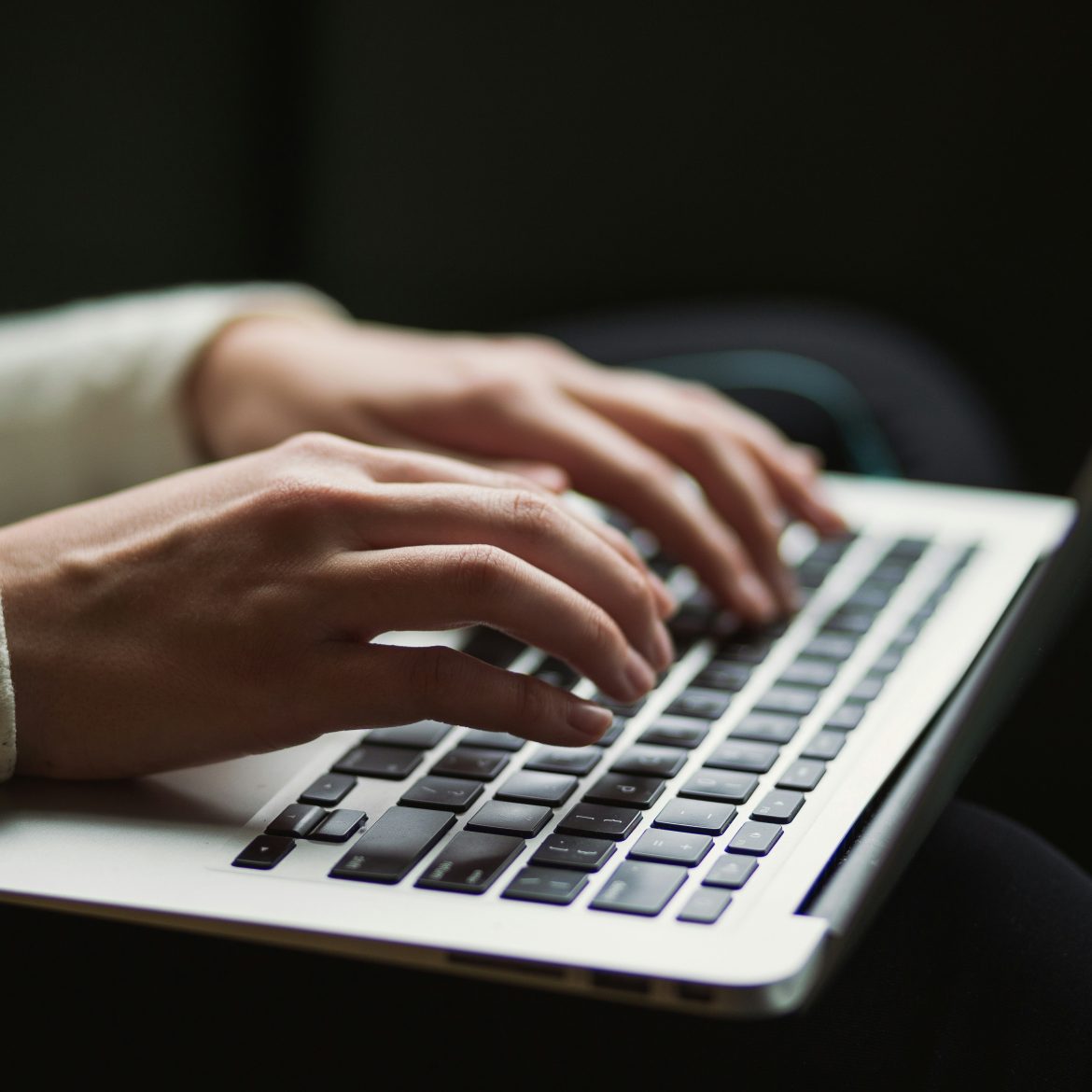 Handen typen op een toetsenbord van een laptop