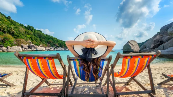 Vrouw die in een stoel zit op het strand