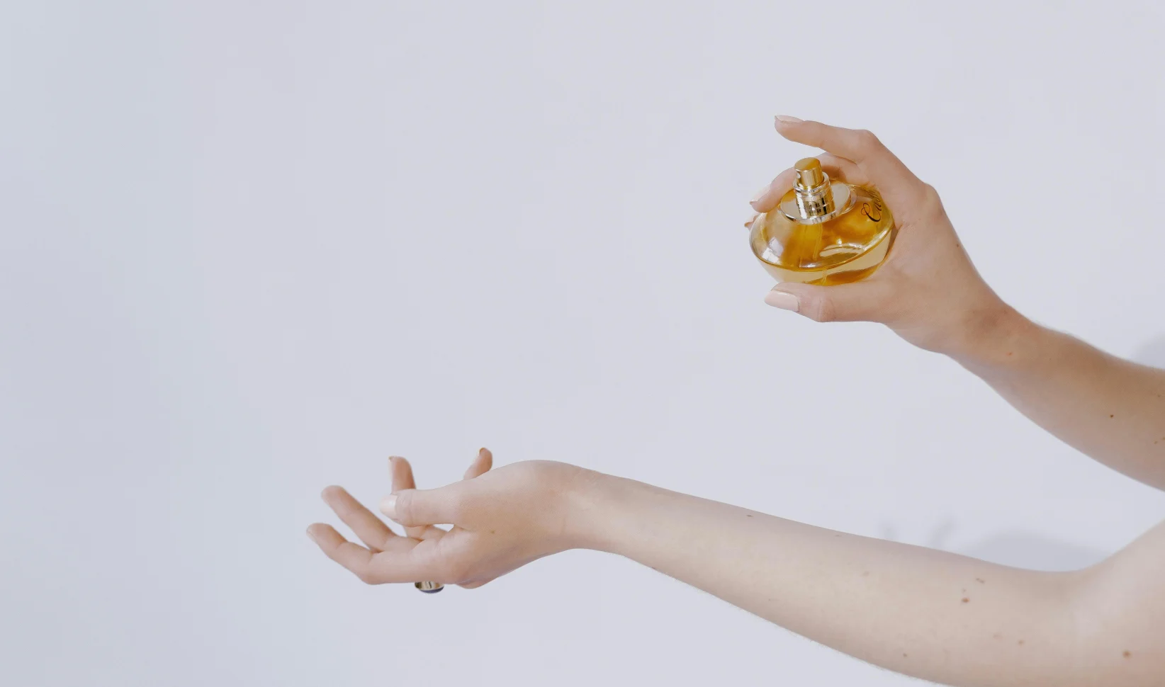 Vrouw sprayt parfum op zonder alcohol