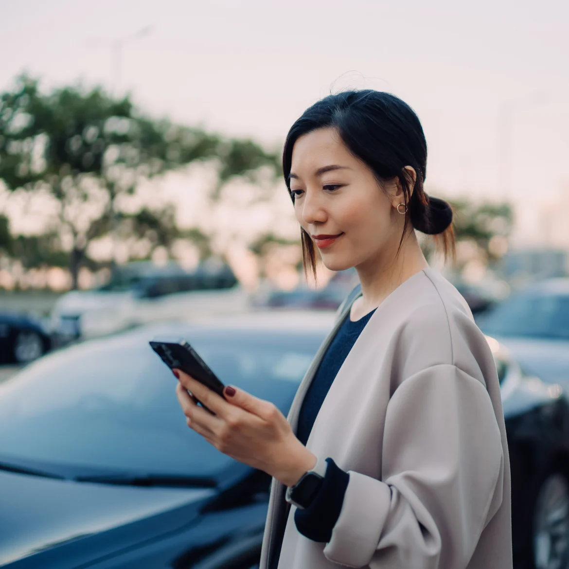vrouw kijkt op telefoon voor haar auto