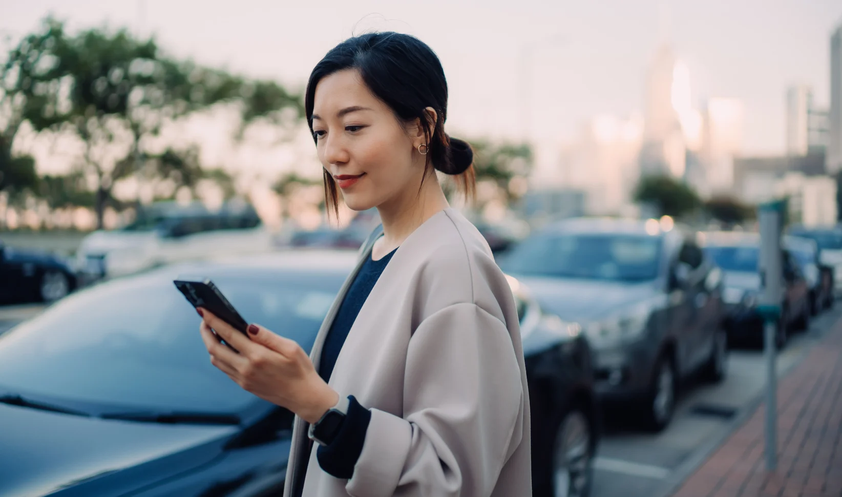 vrouw kijkt op telefoon voor haar auto