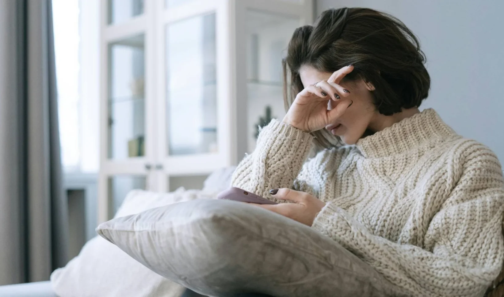 Vrouw huilt met telefoon in hand | Zeldzame stofwisselingsziekte