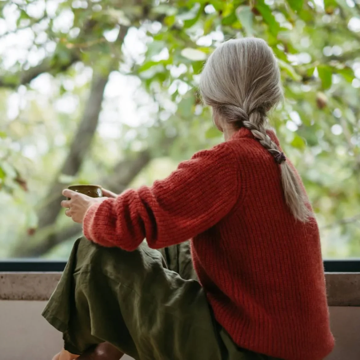 Vrouw kijkt uit raam | oudtante