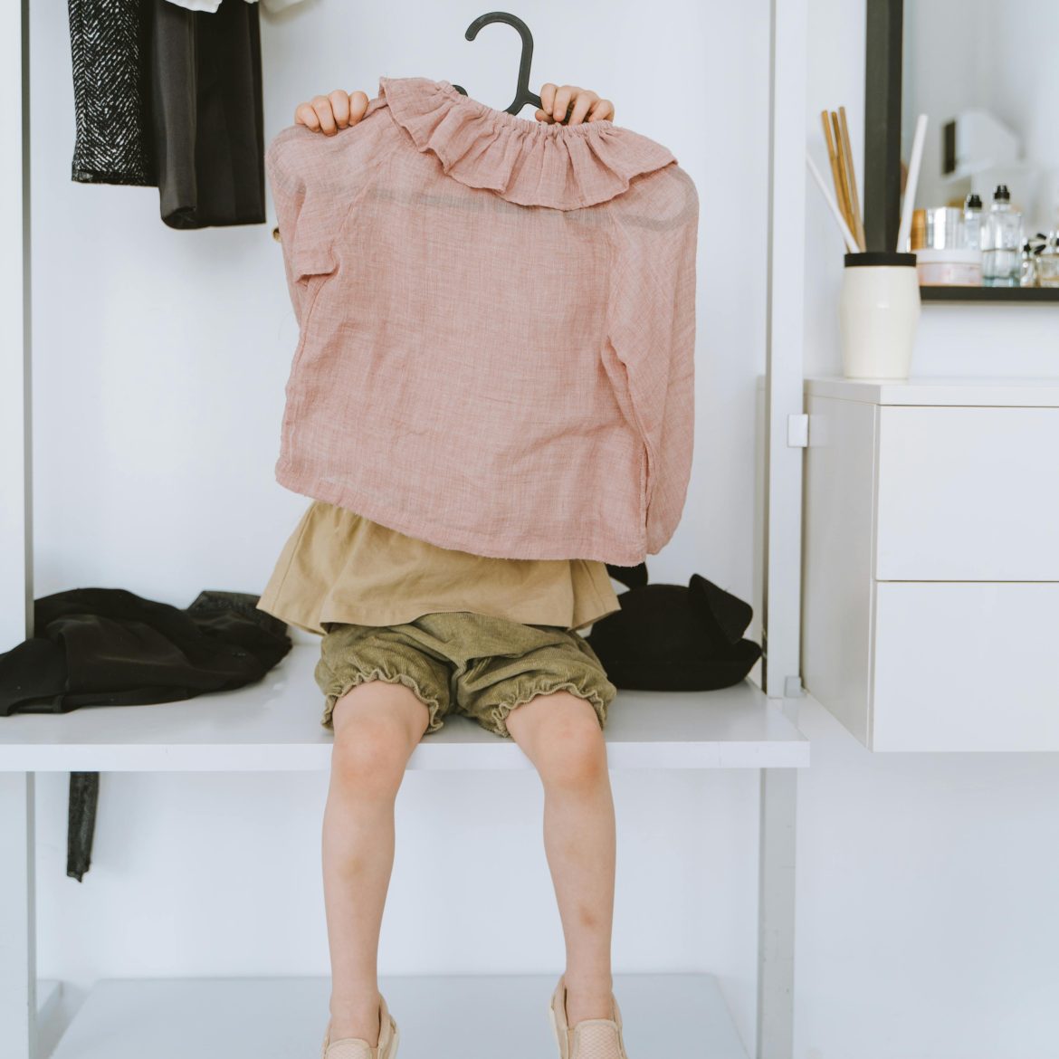 Kind heeft hanger met kleding vast.