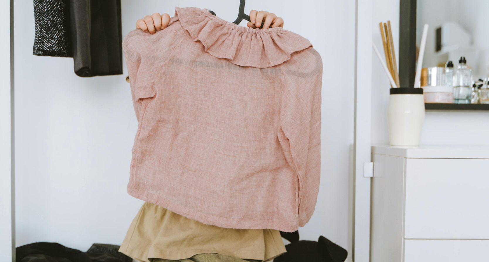 Kind heeft hanger met kleding vast.