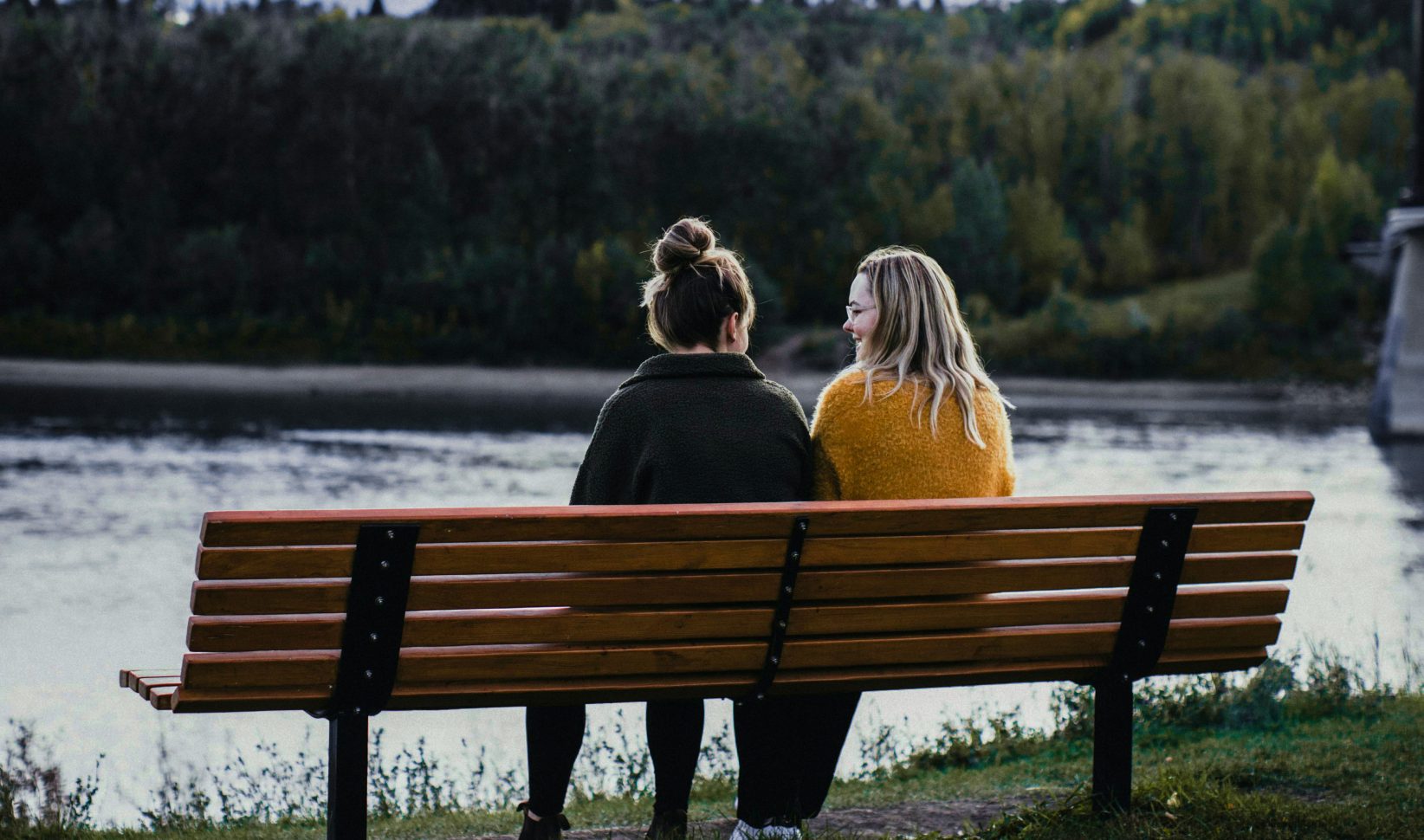 Vrouwen zitten op een bankje.