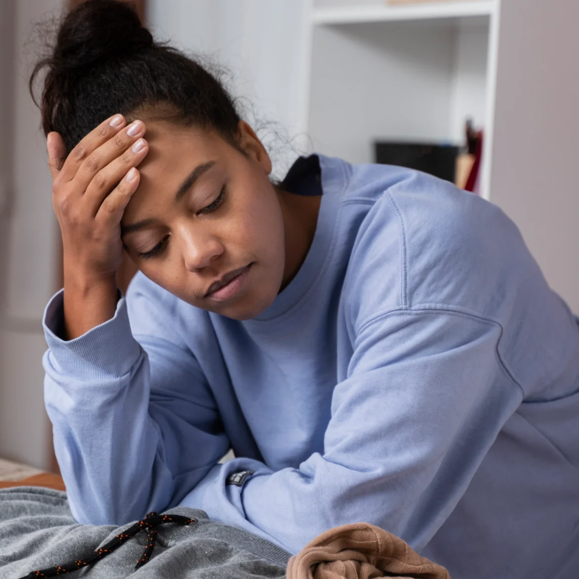 Vrouw buigt over een strijkplank en denkt na over hoe ze zich niet thuis voelt in het huis van haar vriend