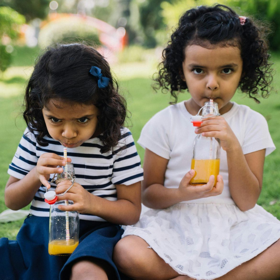 Kinderen drinken uit een flesje.