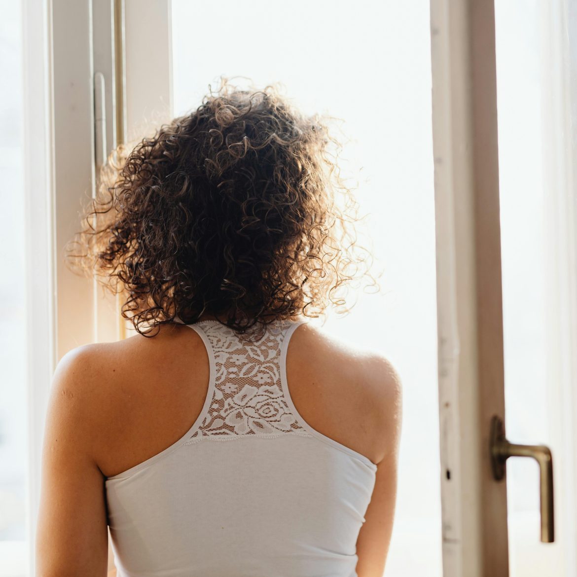 Vrouw kijkend uit het raam.