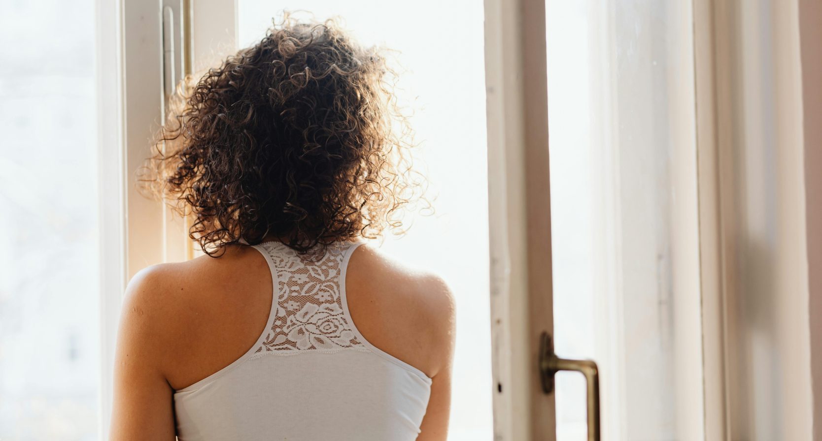 Vrouw kijkend uit het raam.