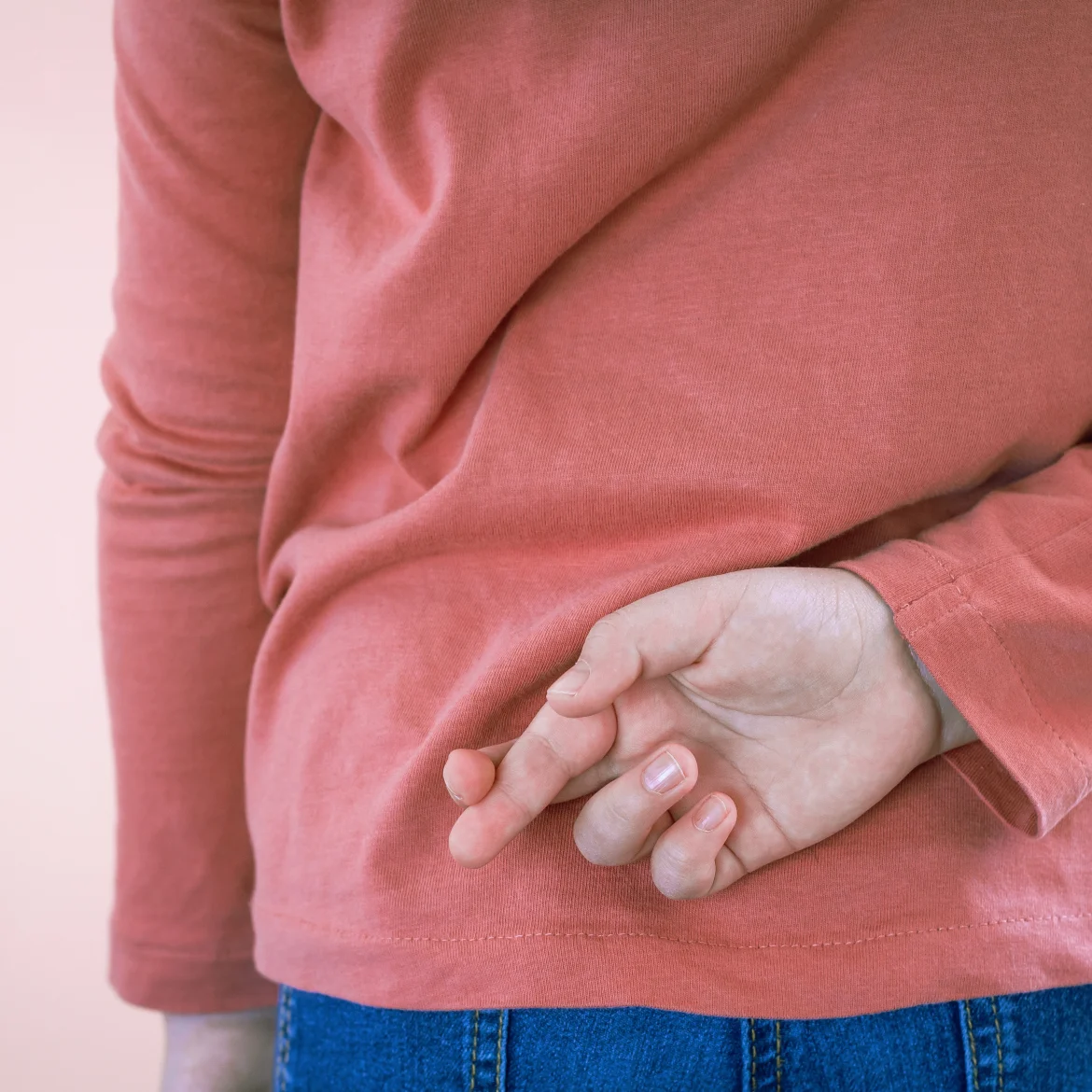 Illustratief beeld van een meisje dat haar vingers gekruisd houdt achter haar rug bij een artikel over een meisje dat per ongeluk het huisdier van haar zus doodde.