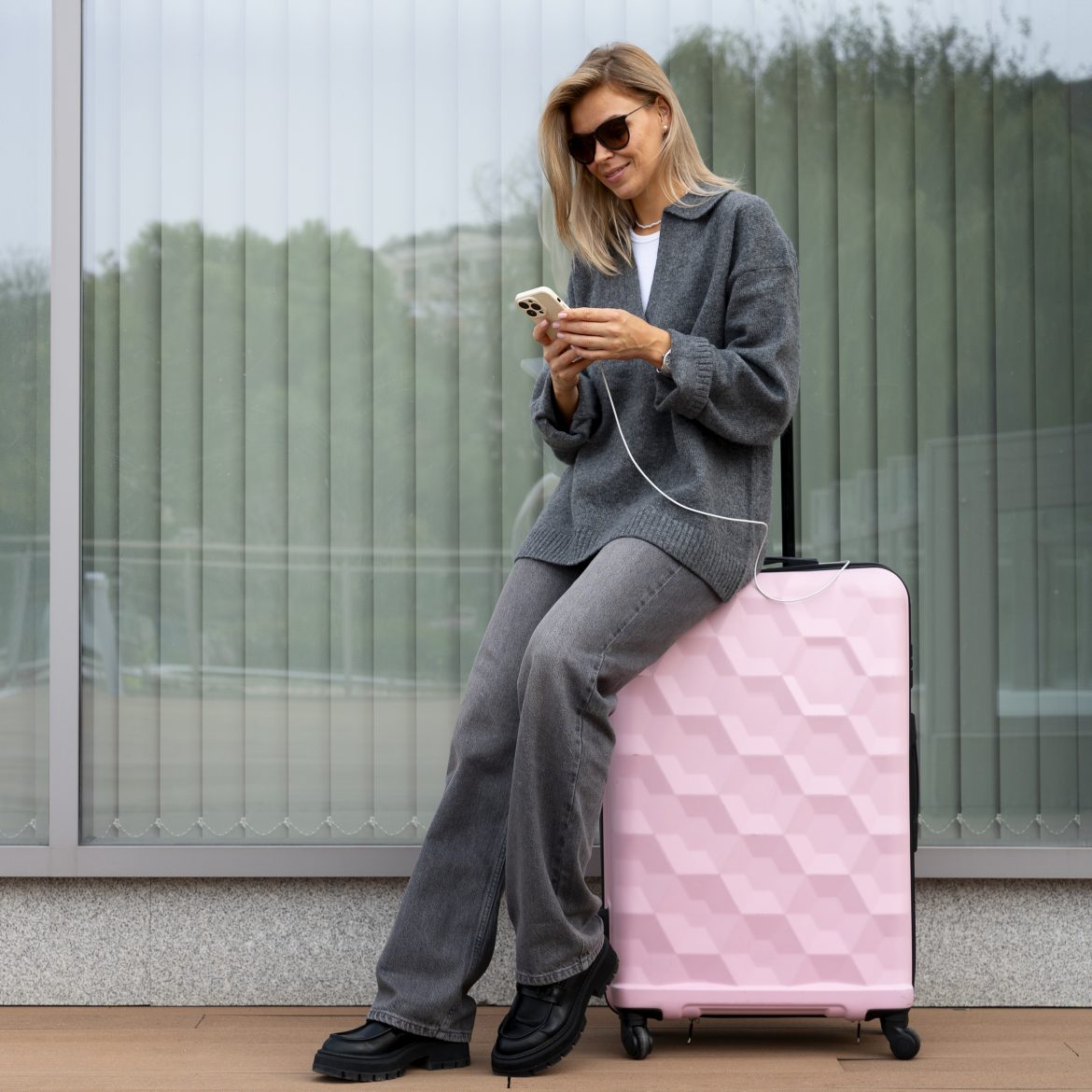 Vrouw op telefoon met koffer.