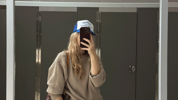 Meisje voor een spiegel met telefoon in haar hand.