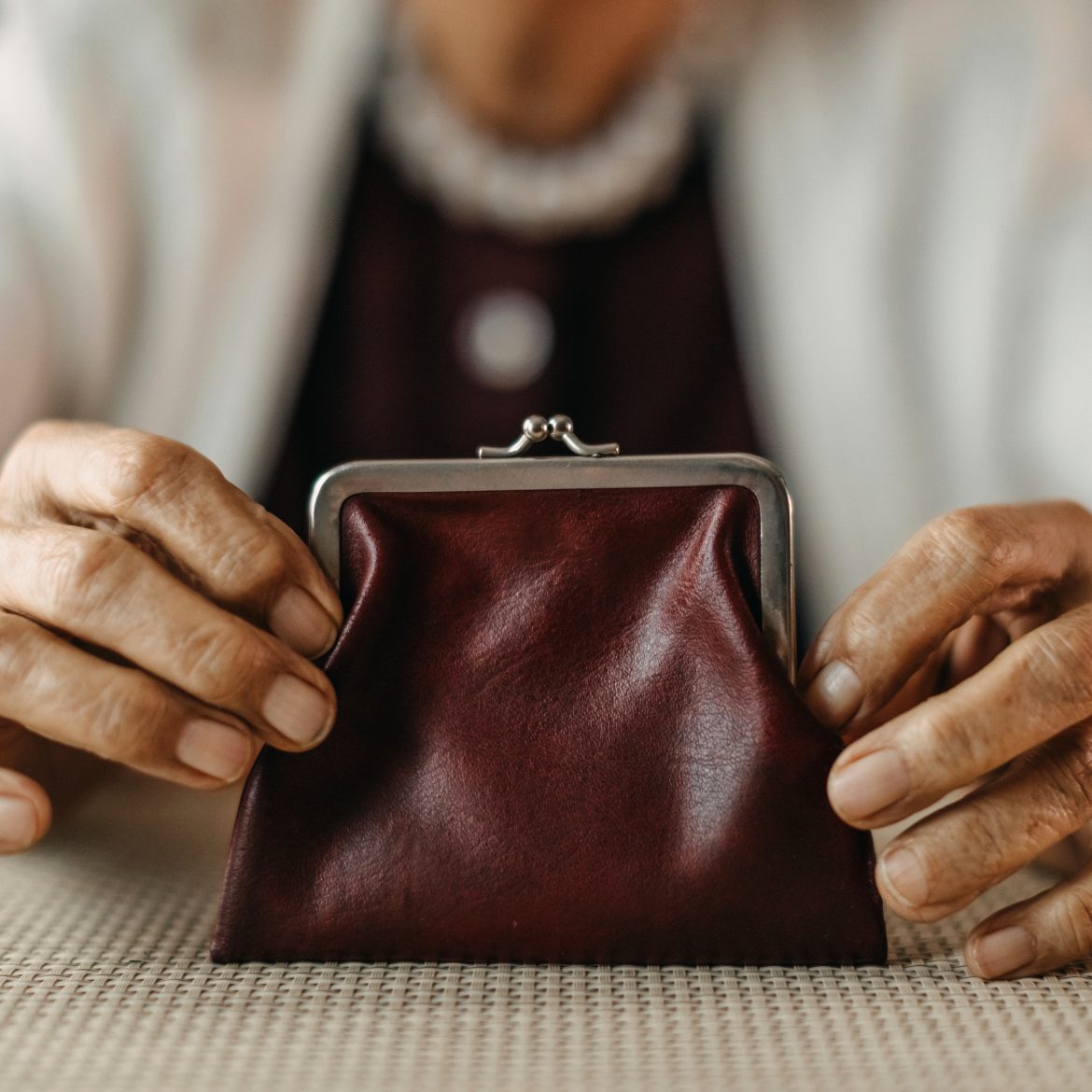 Oude vrouw heeft een rode portemonnee vast