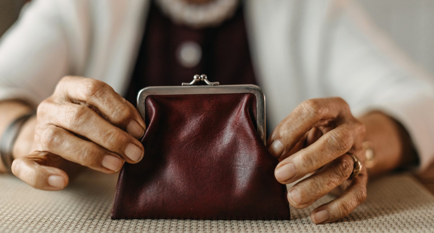 Oude vrouw heeft een rode portemonnee vast