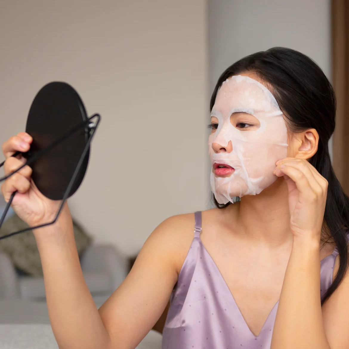 Vrouw is gezichtsmasker opdoen op bed