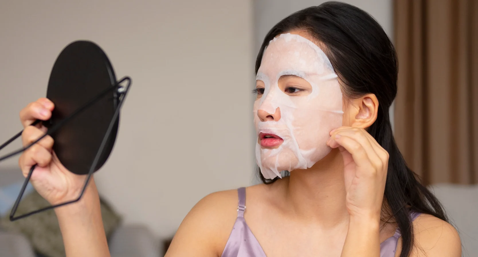 Vrouw is gezichtsmasker opdoen op bed