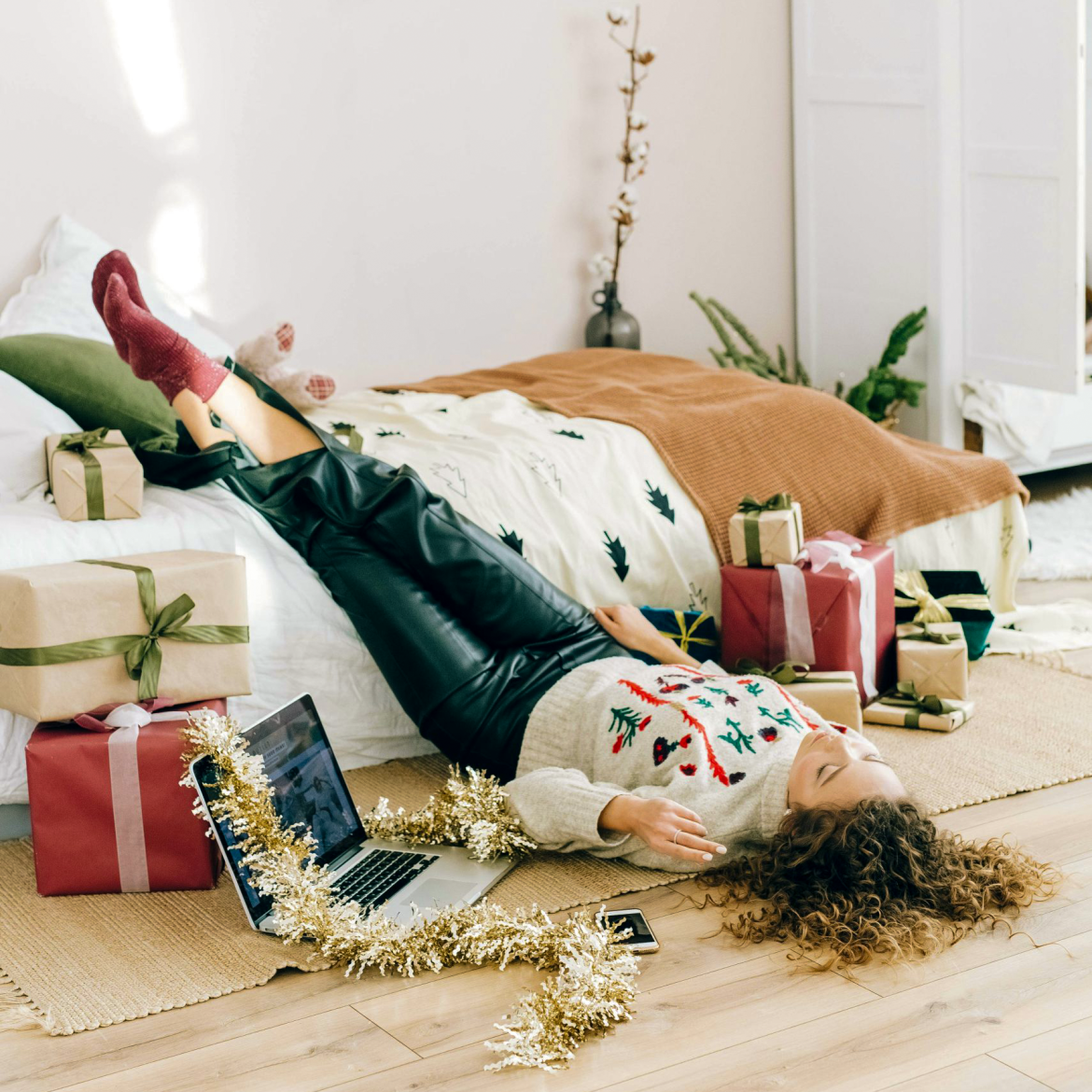 Vrouw bij bed in kerstsetting.