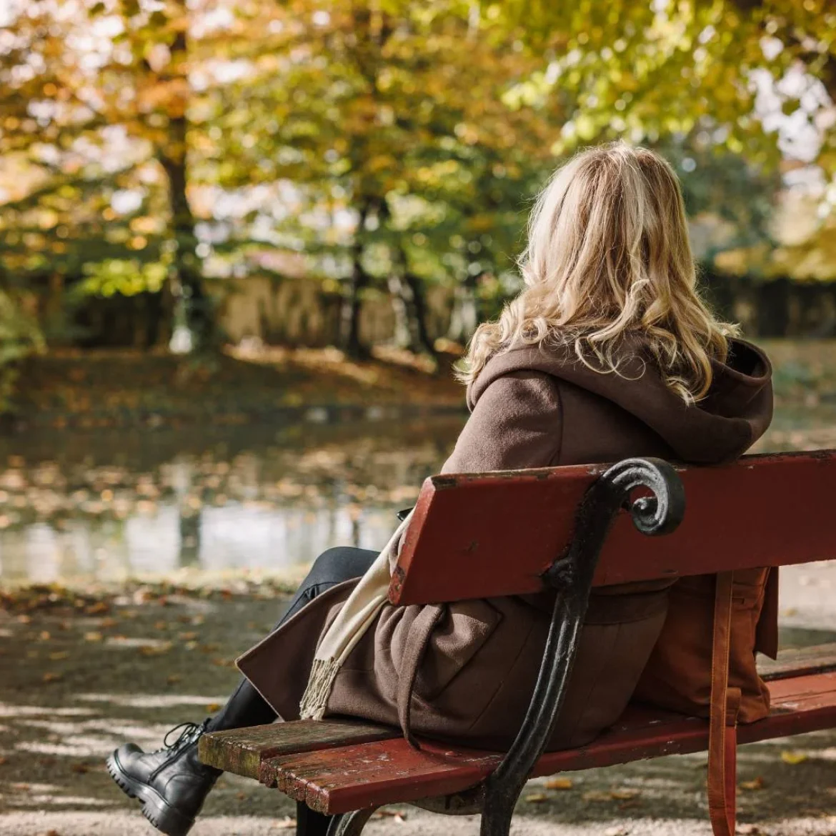 Vrouw op bankje | buitengesloten schoolplein