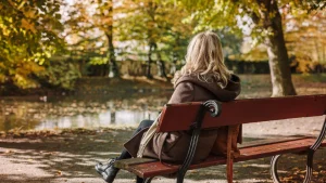 Vrouw op bankje | buitengesloten schoolplein