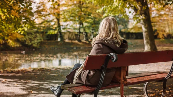 Vrouw op bankje | buitengesloten schoolplein