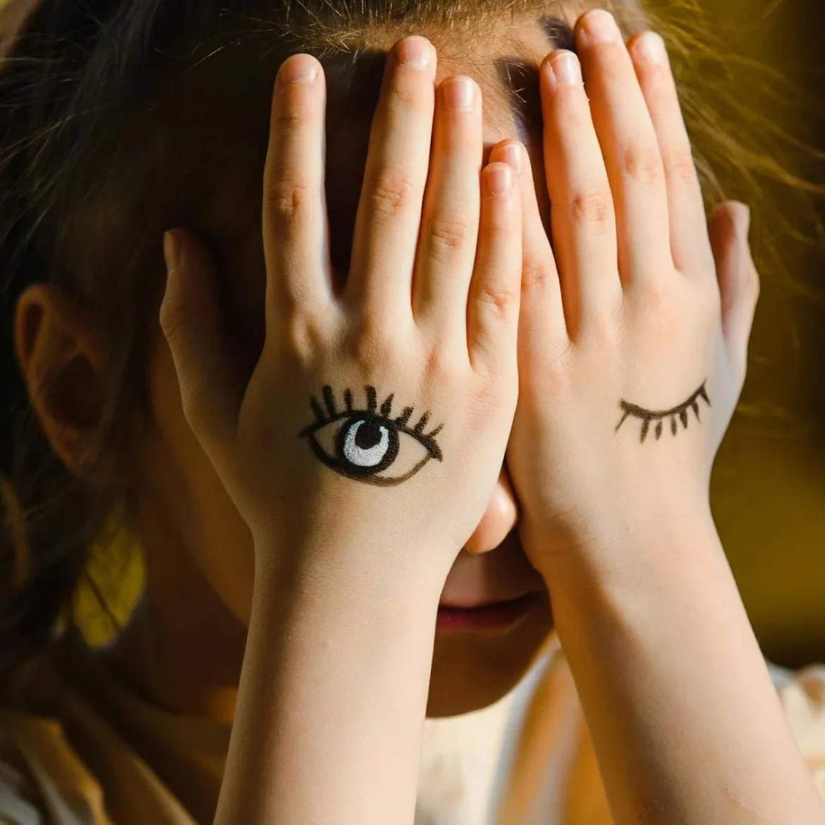 Kind bedekt gezicht met handen