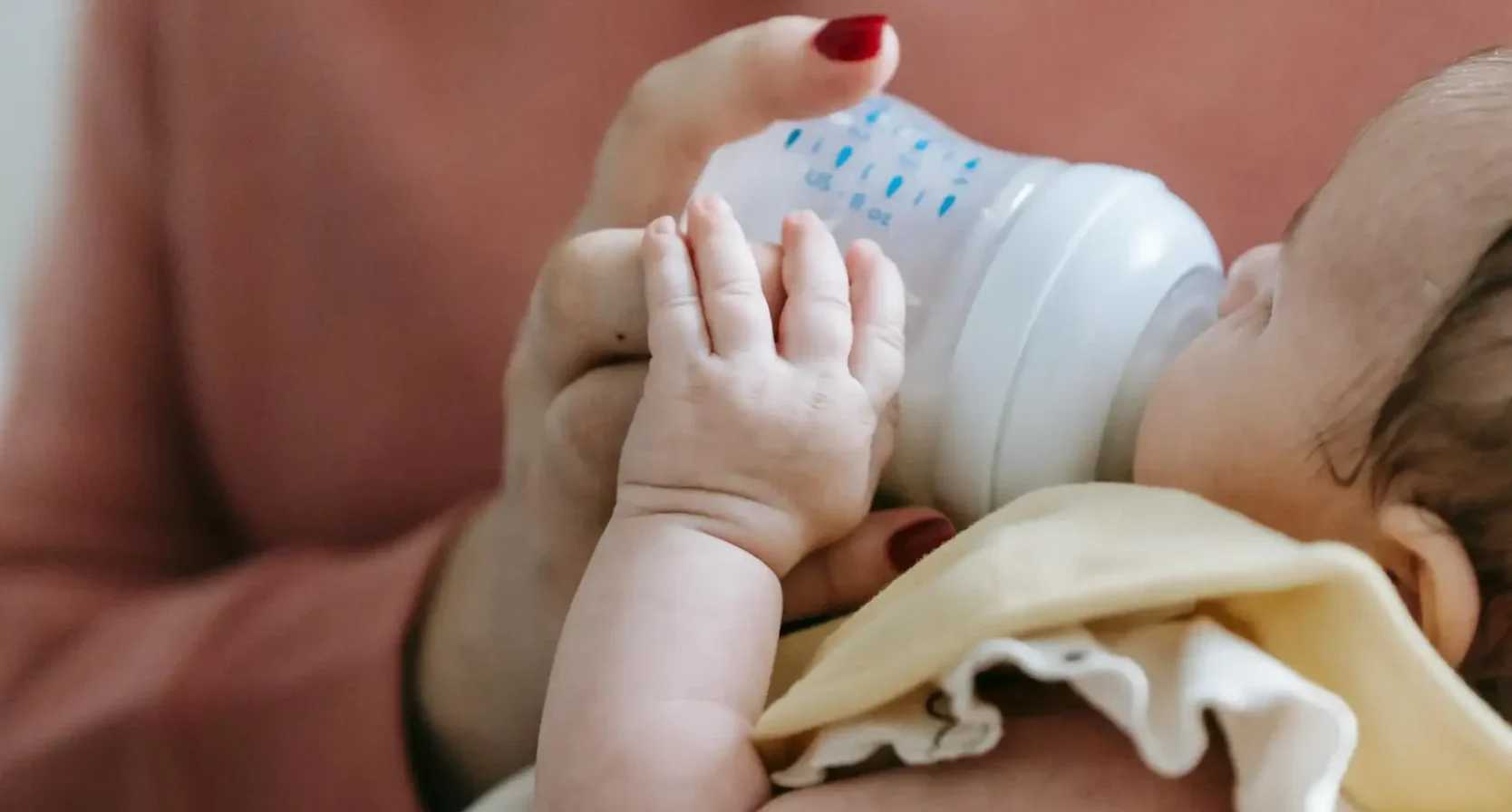 Vrouw geeft baby babyvoeding met fles