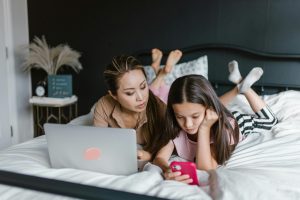 kind, moeder, social media, online buitensluiten, telefoon, bed