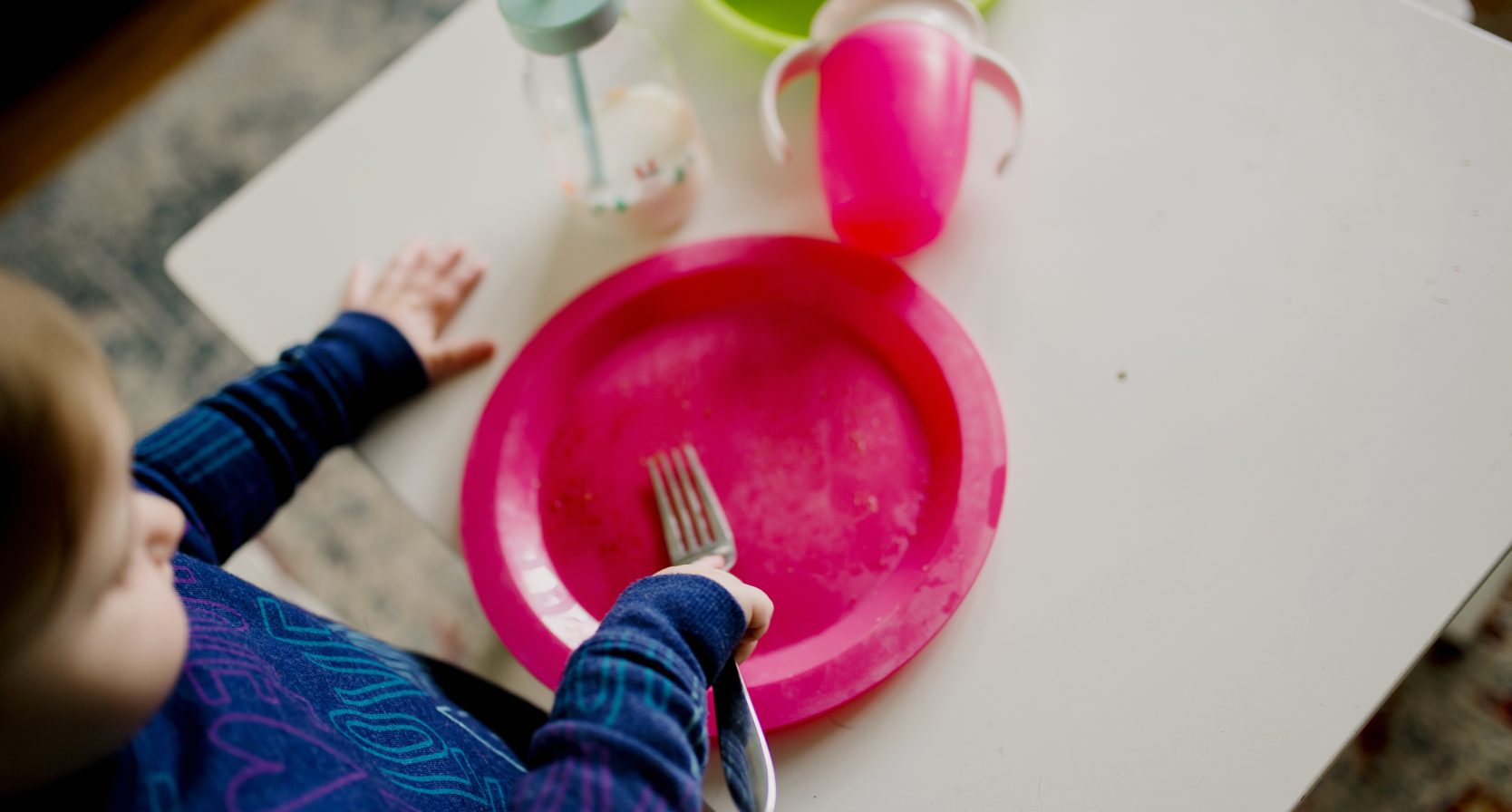 Kind met bord en vork