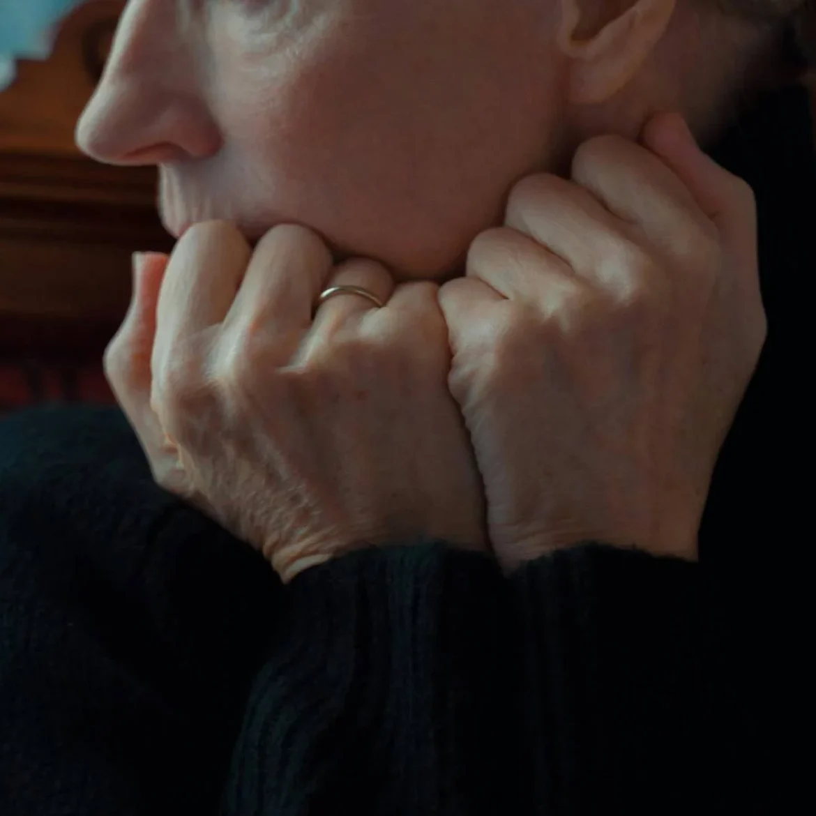 Oude vrouw met handen in gezicht