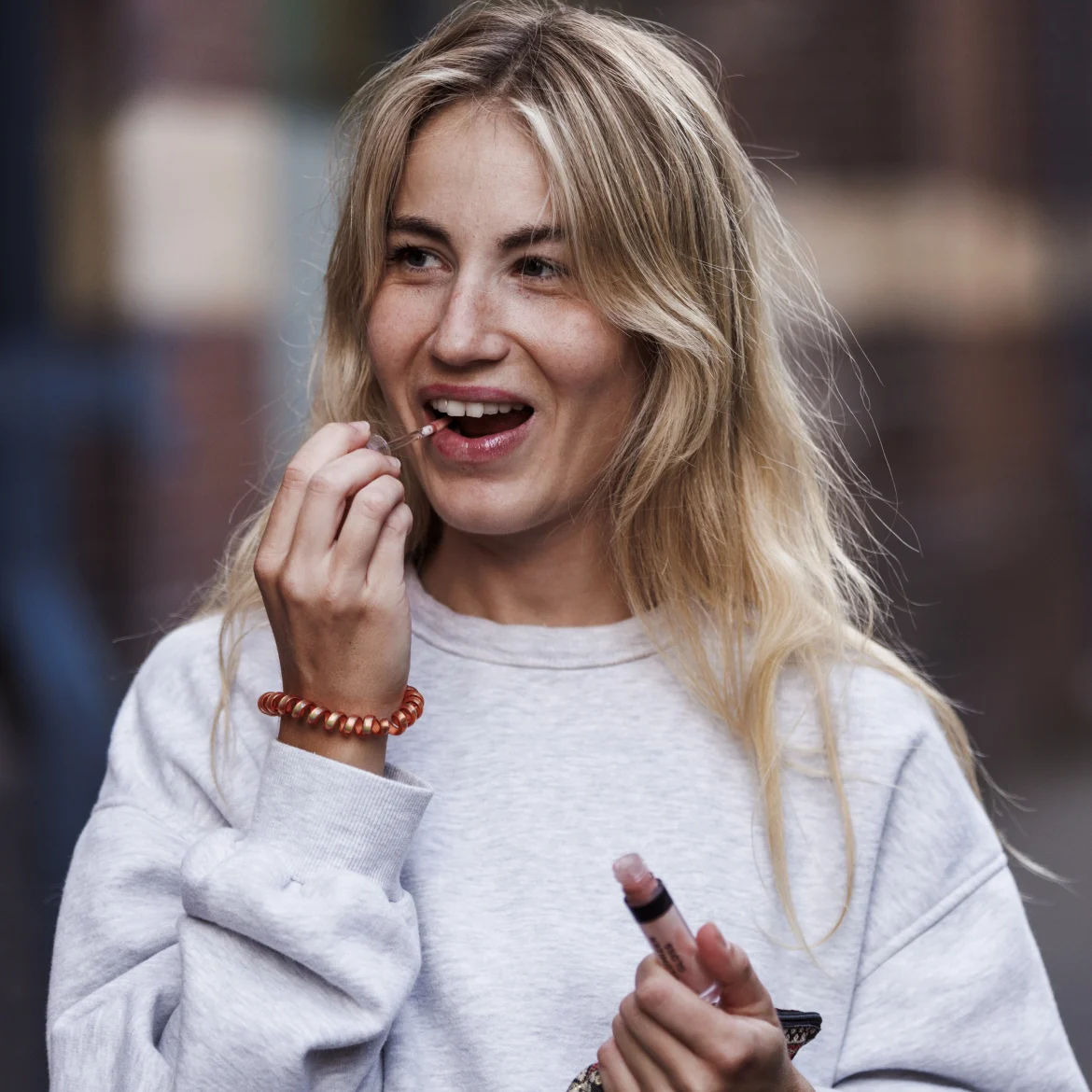 Vrouw smeer lipgloss op haar lippen